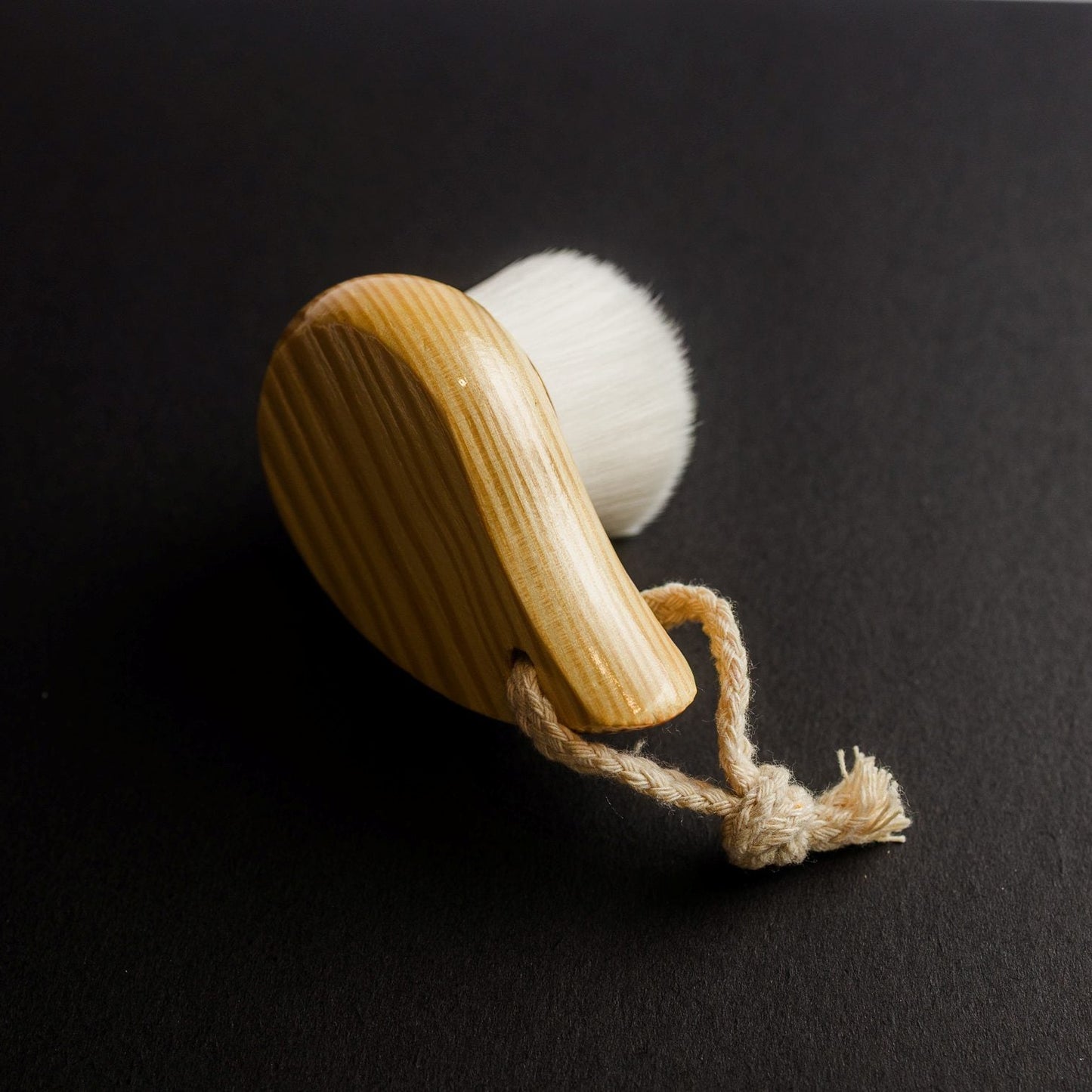 Wooden Facial Cleansing Brush lying on a side