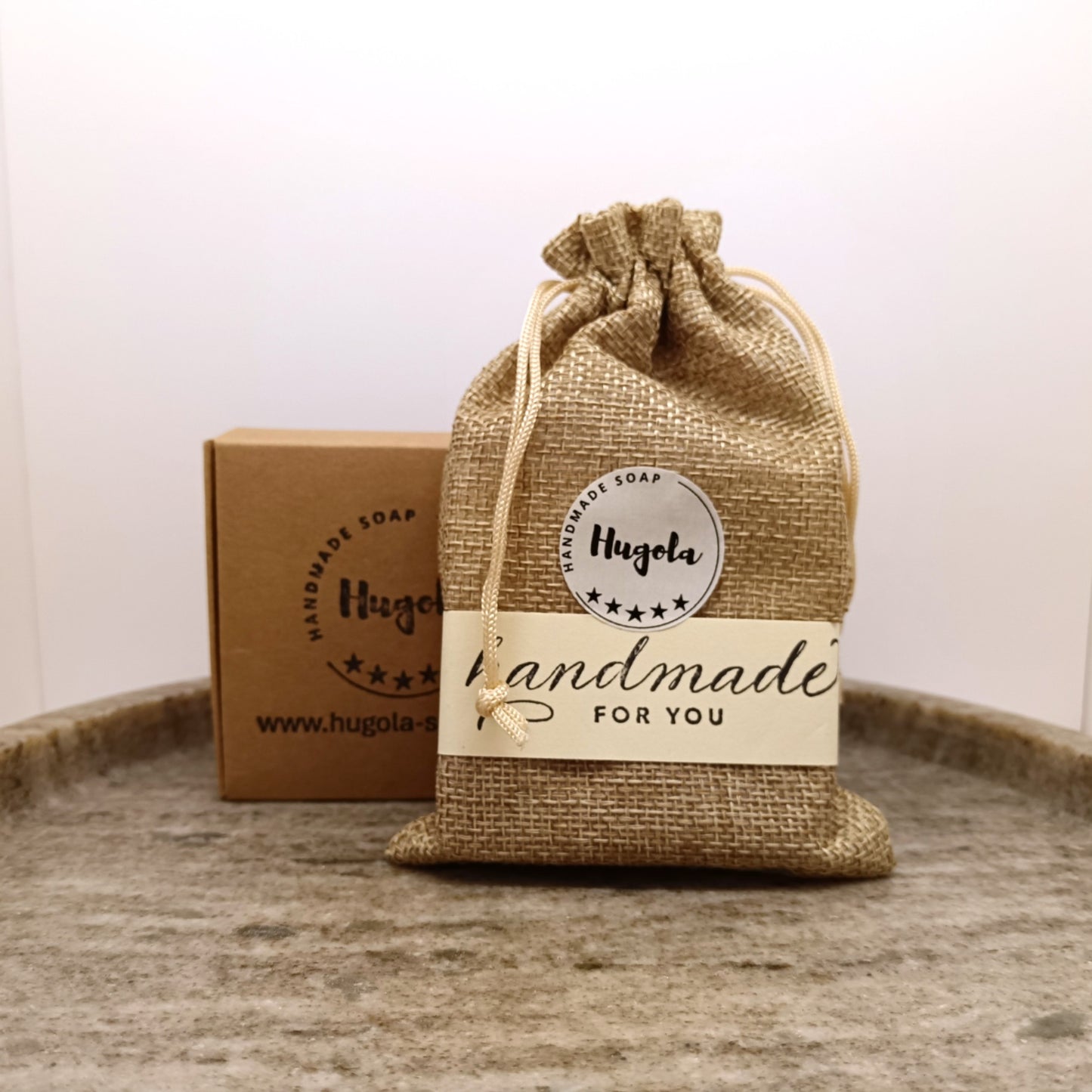 Hugola soap in a burlap bag and second one in eco friendly paper packaging