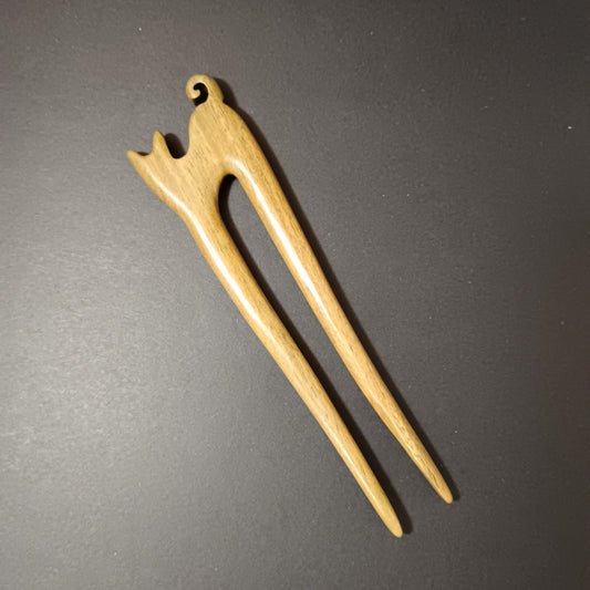 Wooden cat-shaped hair pin on a dark gray background