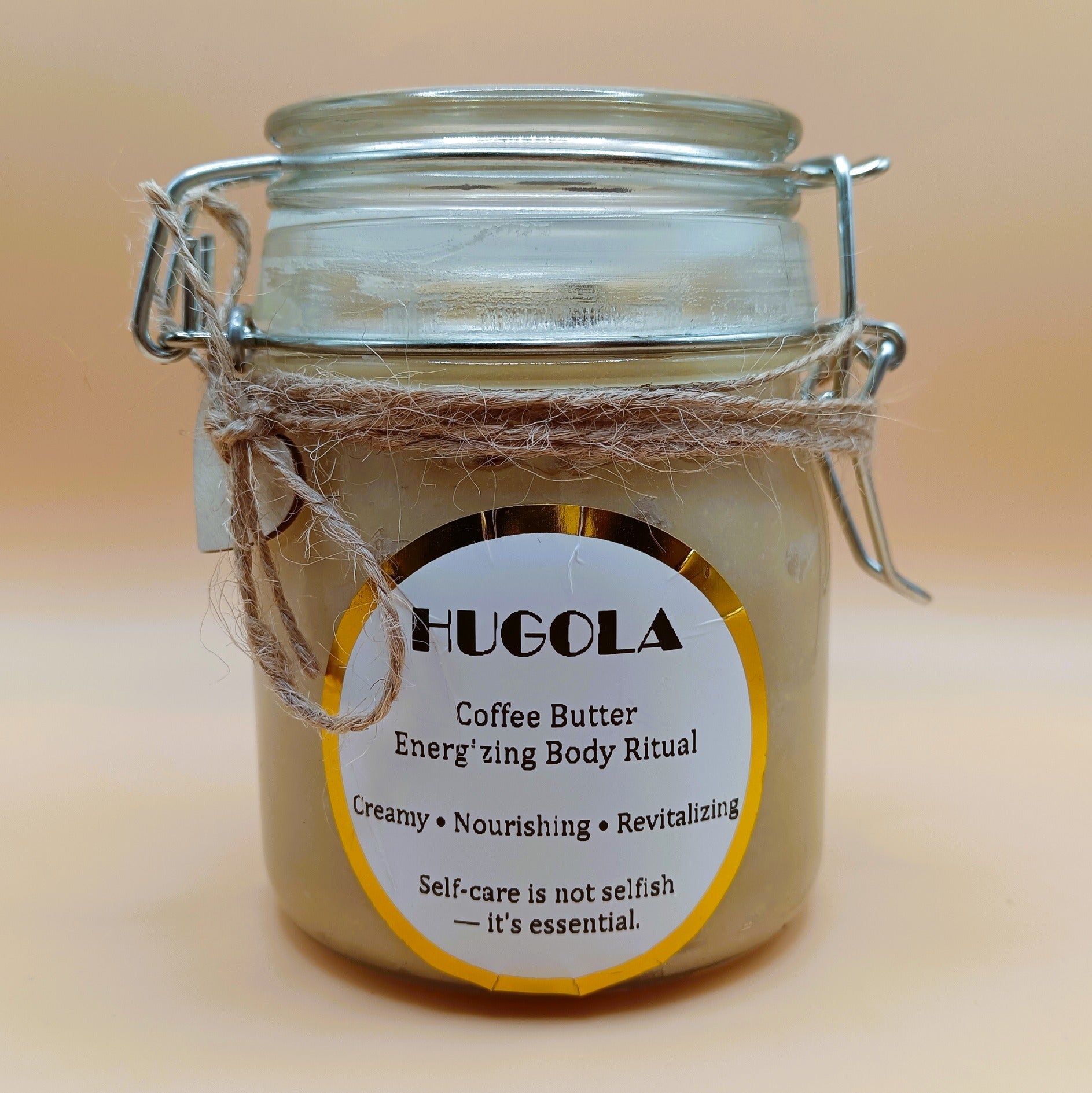Jar of Hugola coffee butter with a label on a beige background
