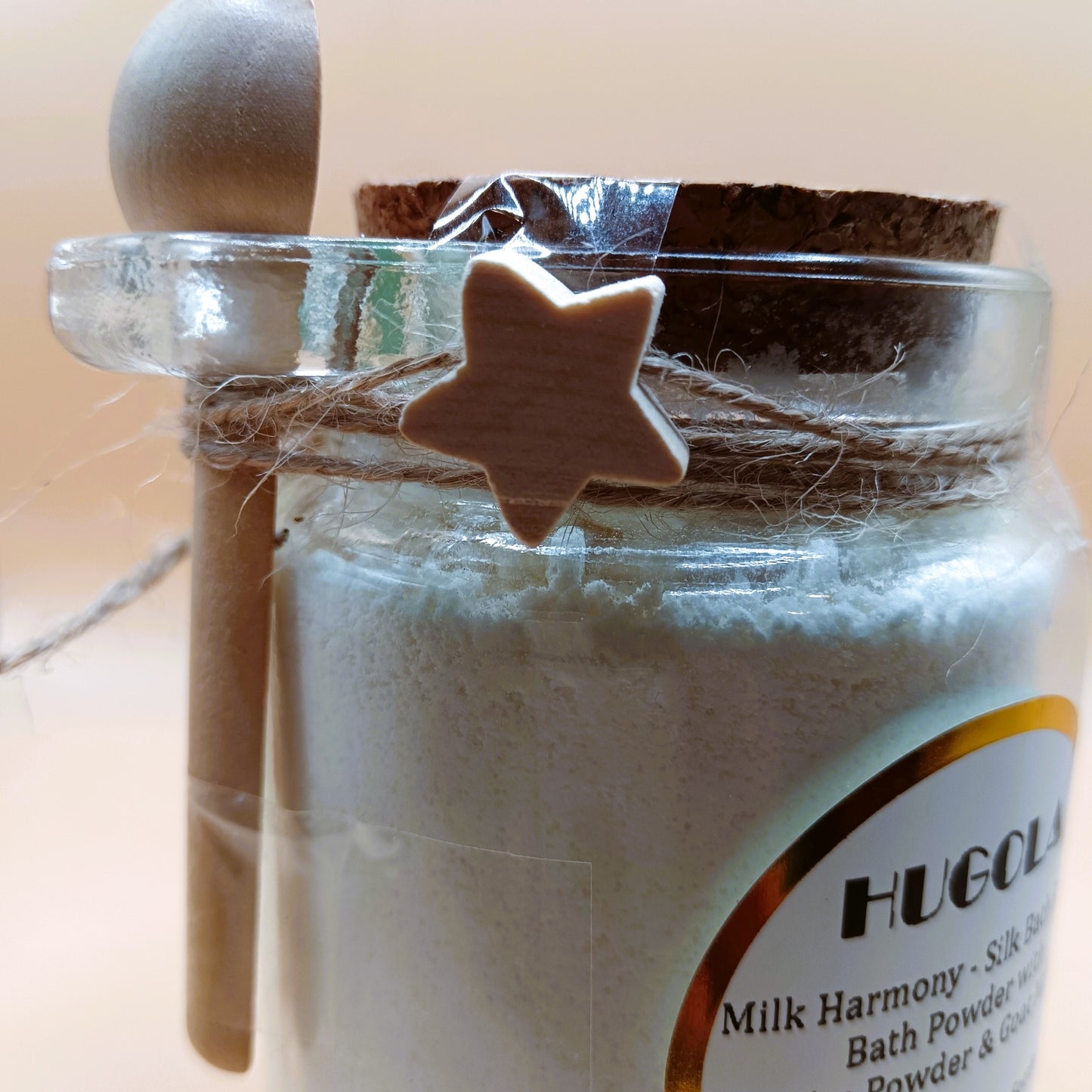 Close-up on Milk Harmony bath powder glass jar with cork lid and wooden spoon