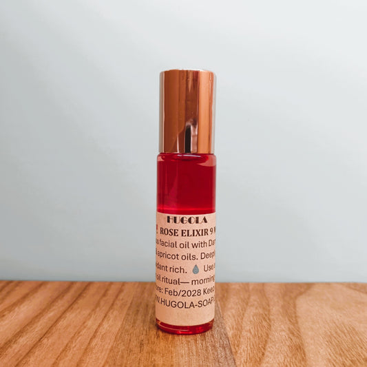 Glass roll-on bottle filled with rose elixir oil on a natural background