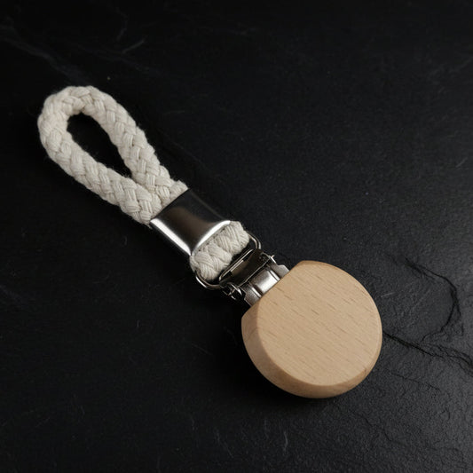 Beige towel hanger with clip on a rope on a dark gray background