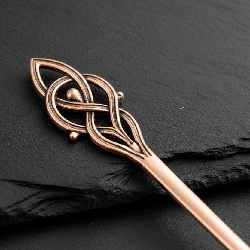 Copper hairpin with Viking-style design on a gray background