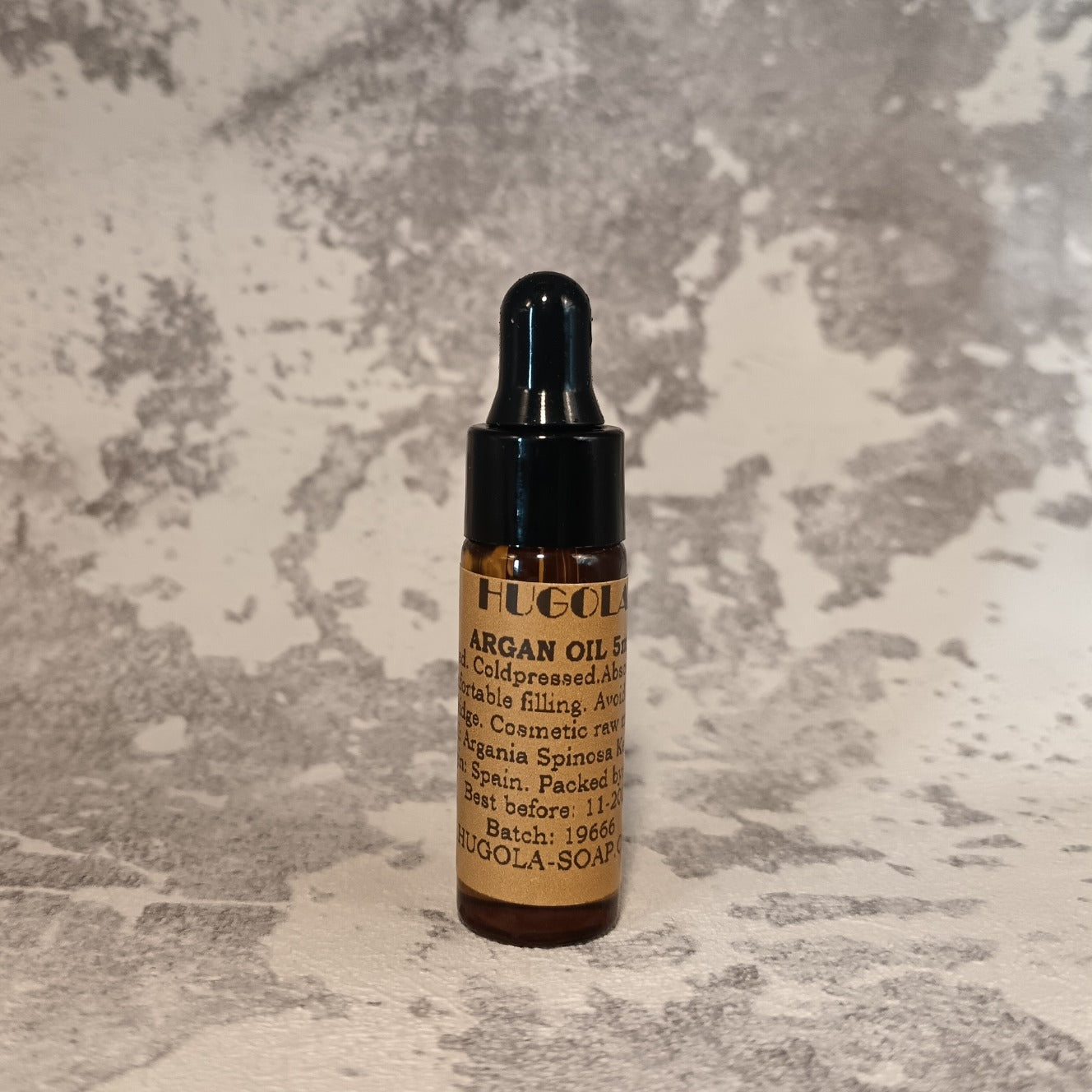 5ml argan oil mini bottle for face and hair care on marble background
