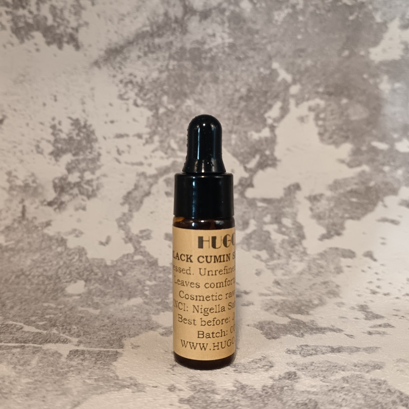 5ml black cumin seed oil travel bottle for skin and hair on texture surface