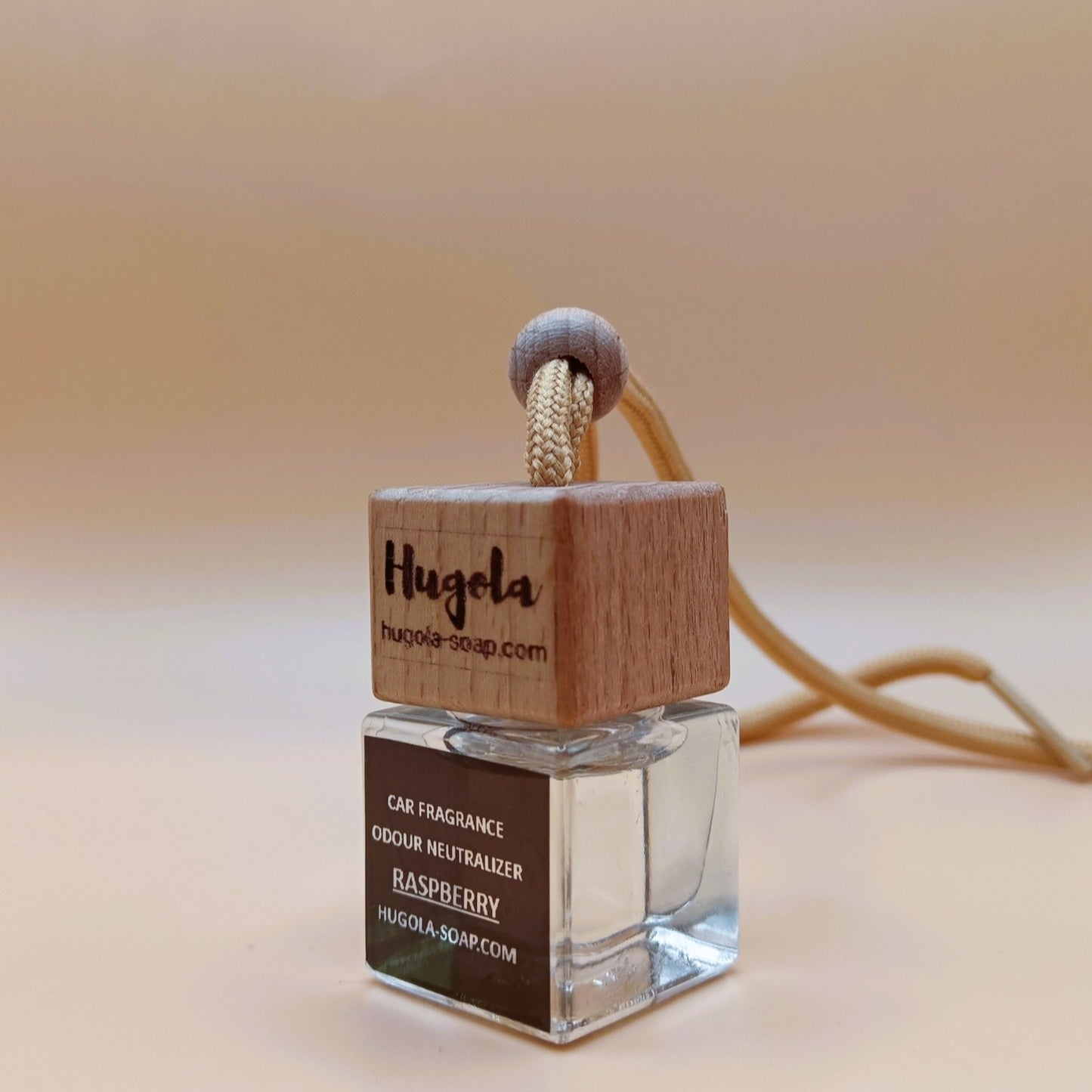 Hugola car fragrance diffuser, Raspberry scent, angled view of glass bottle with wooden lid