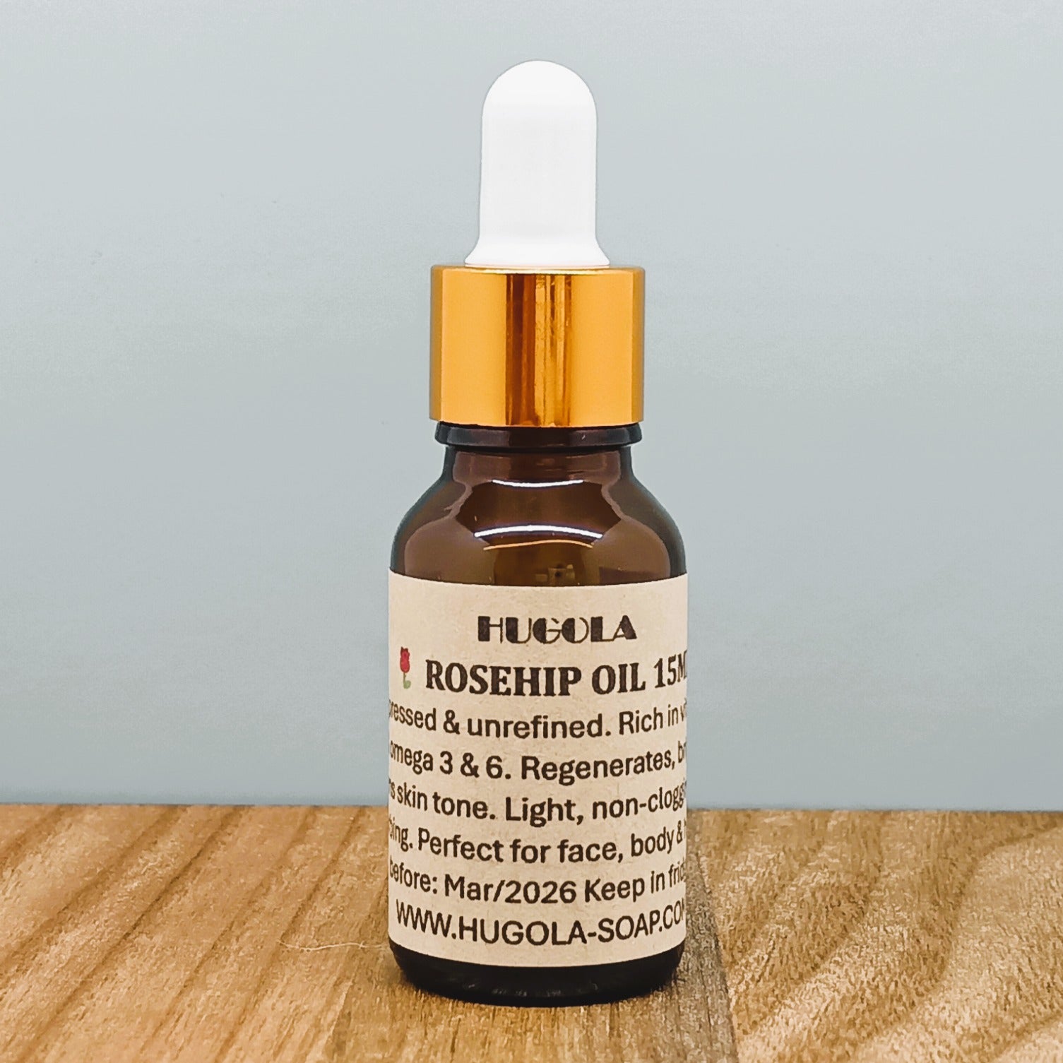 Rosehip Seed Oil, natural cold-pressed oil in glass bottle with radiant orange hue