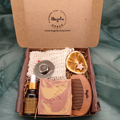 Open box containing skincare products and a comb with Hugola branding on a textured green background.