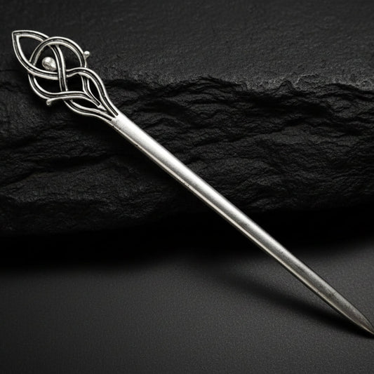Silver decorative hairpin on a dark gray background