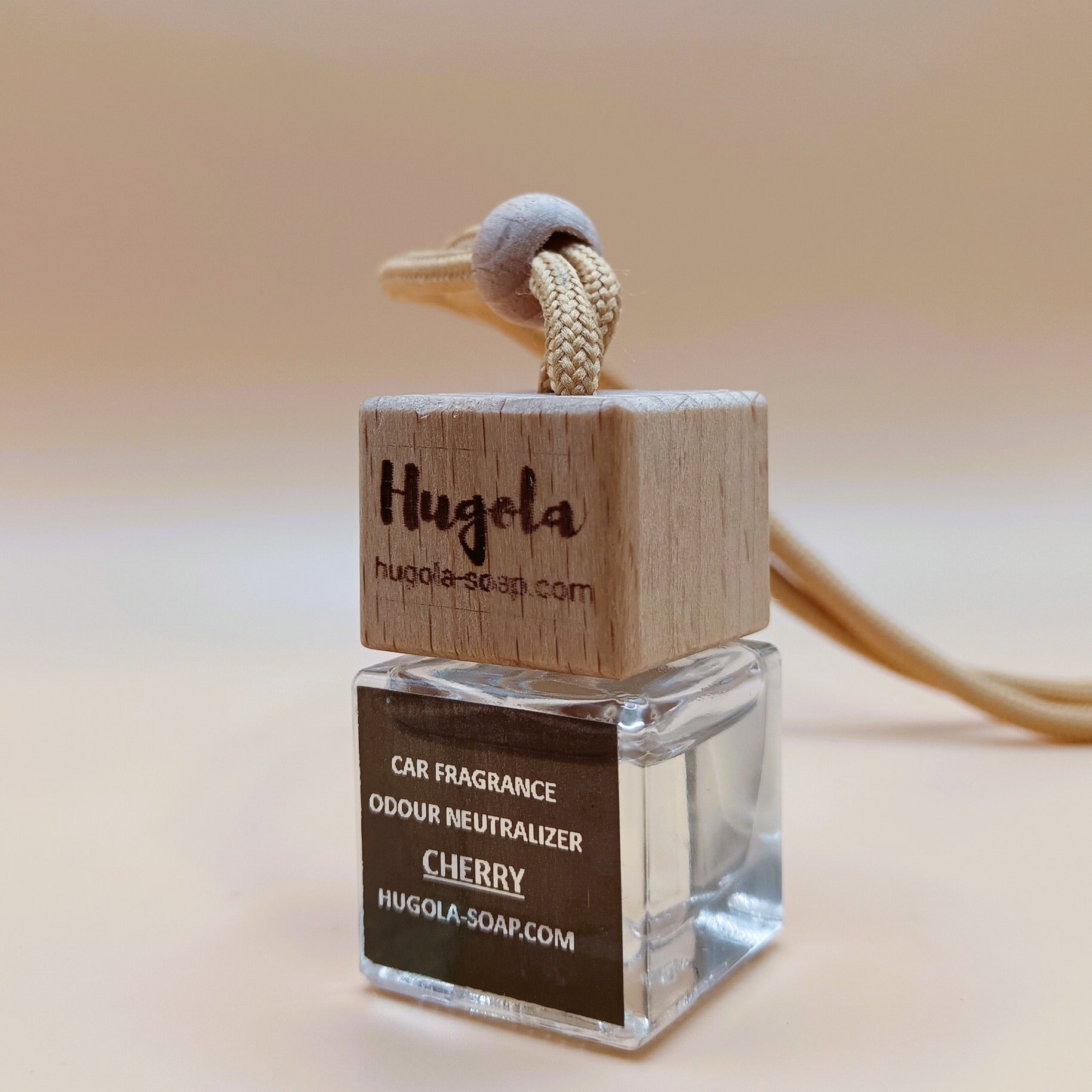 Hugola car fragrance diffuser, Cherry scent, angled view of glass bottle with wooden lid