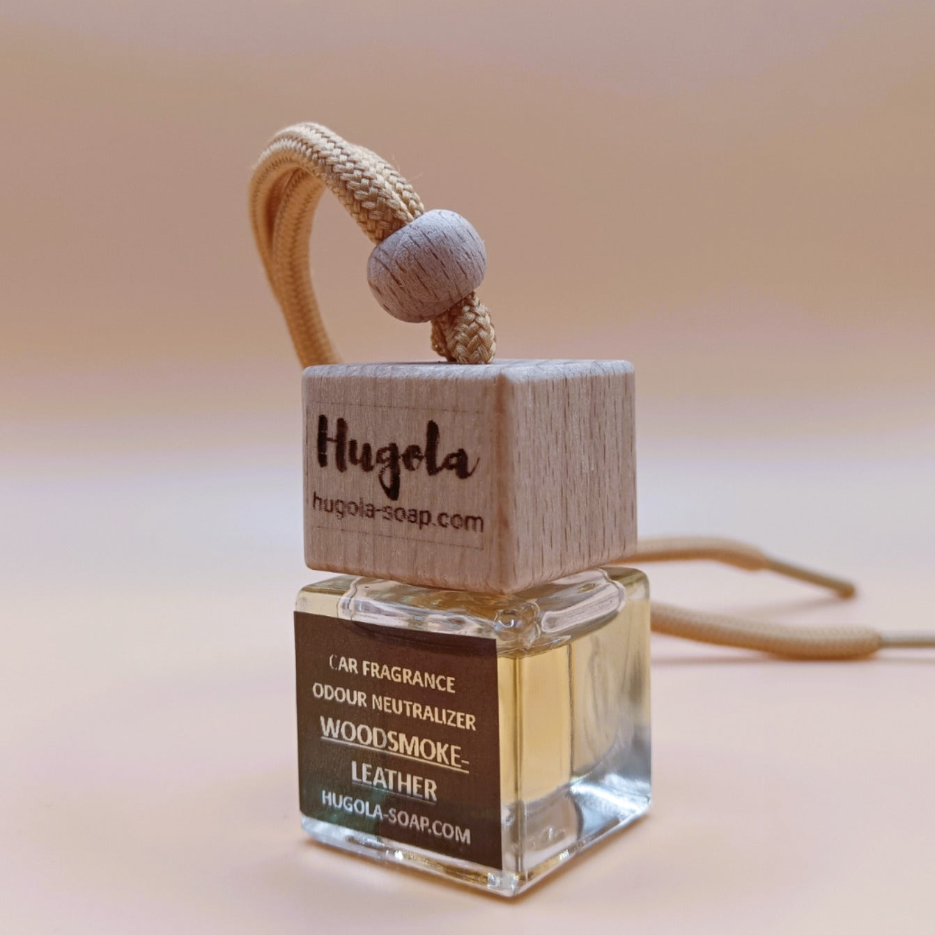 Hugola car fragrance diffuser, Woodsmoke & Leather scent, angled view of glass bottle with wooden lid