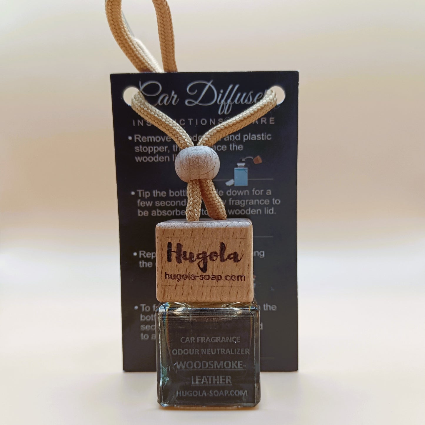Hugola car fragrance diffuser, Woodsmoke & Leather scent, displayed with instruction card and wooden cap