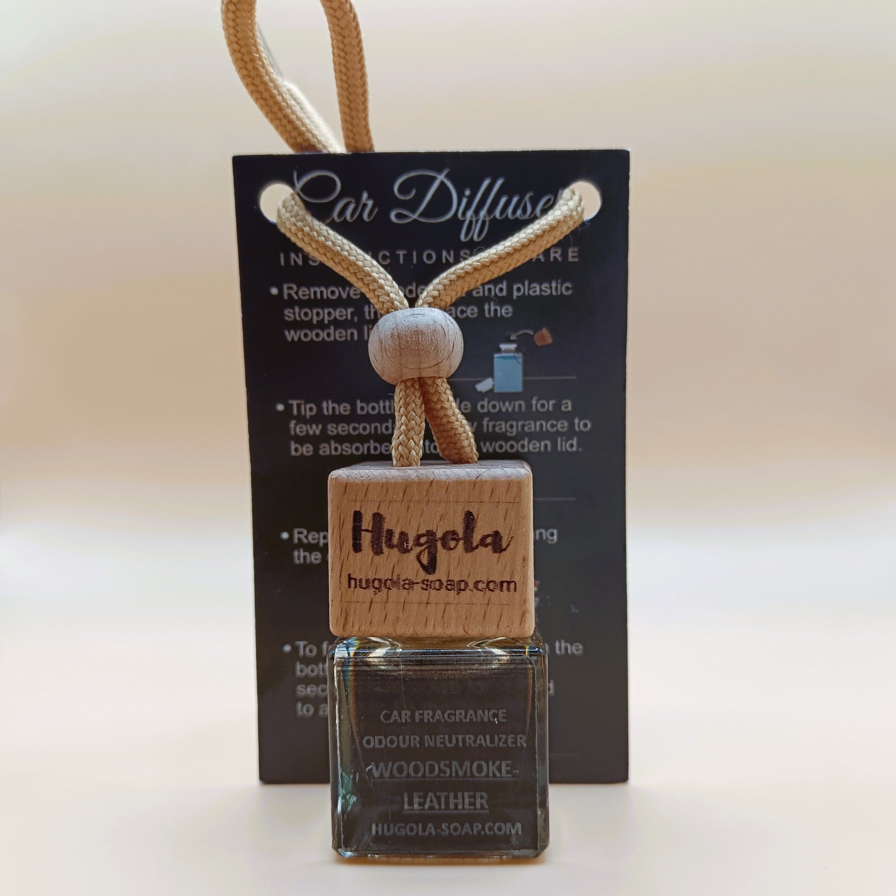 Hugola car fragrance diffuser, Woodsmoke & Leather scent, displayed with instruction card and wooden cap